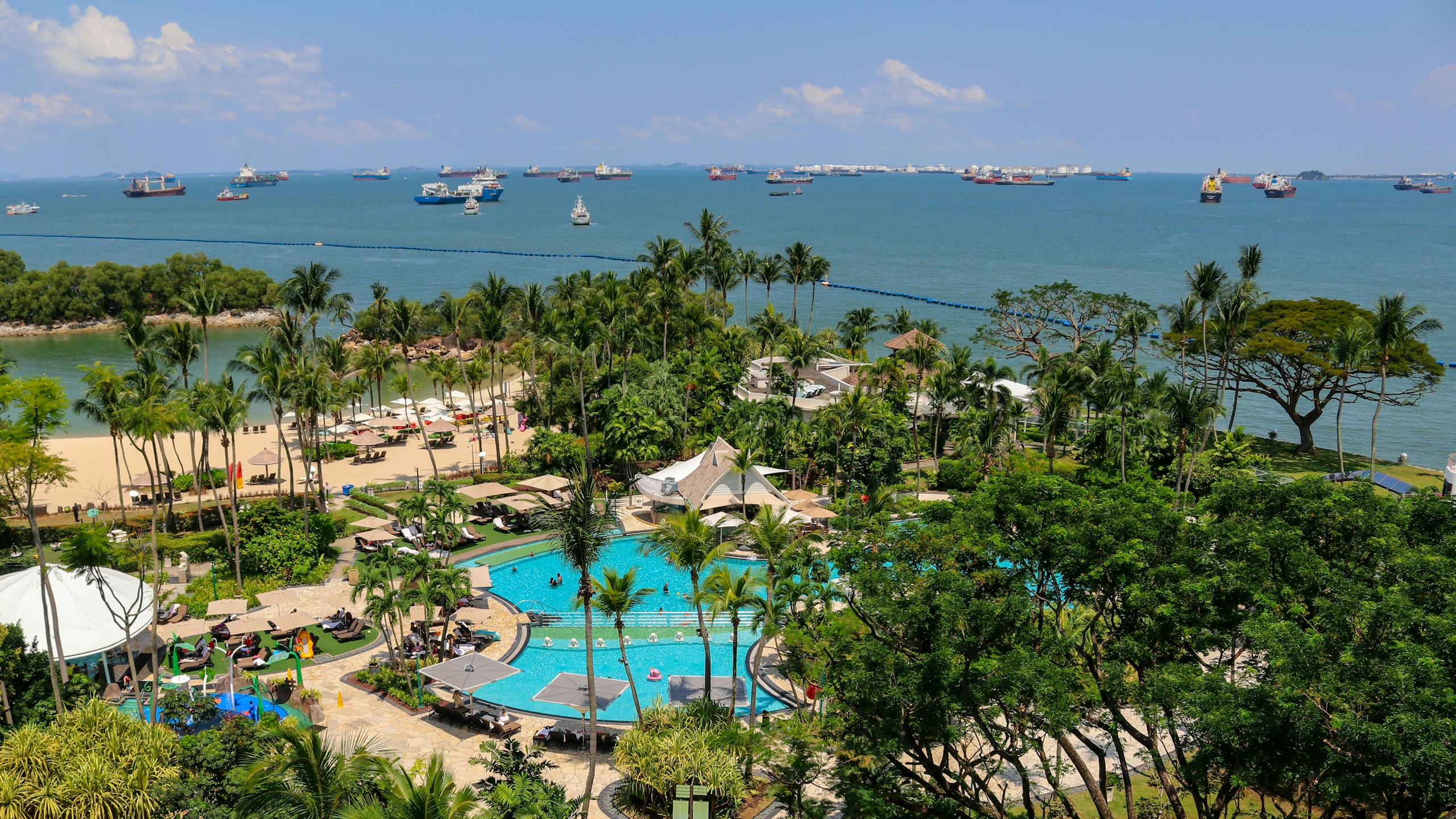 A captivating aerial view of Sentosa resort with lush greenery and the sea in Singapore.